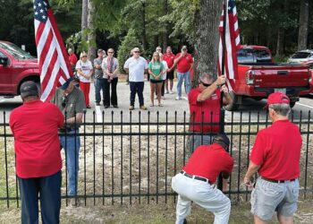 Elliott family watch as two new U.S. Flags are erected at the Veterans and 1st Responders Memorial Park