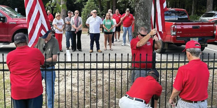 Elliott family watch as two new U.S. Flags are erected at the Veterans and 1st Responders Memorial Park